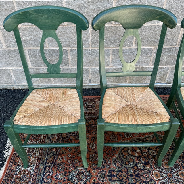 A set of 4 vintage Pottery Barn Napoleon dining chairs in distressed green with woven rush seats. Hand crafted in Italy....