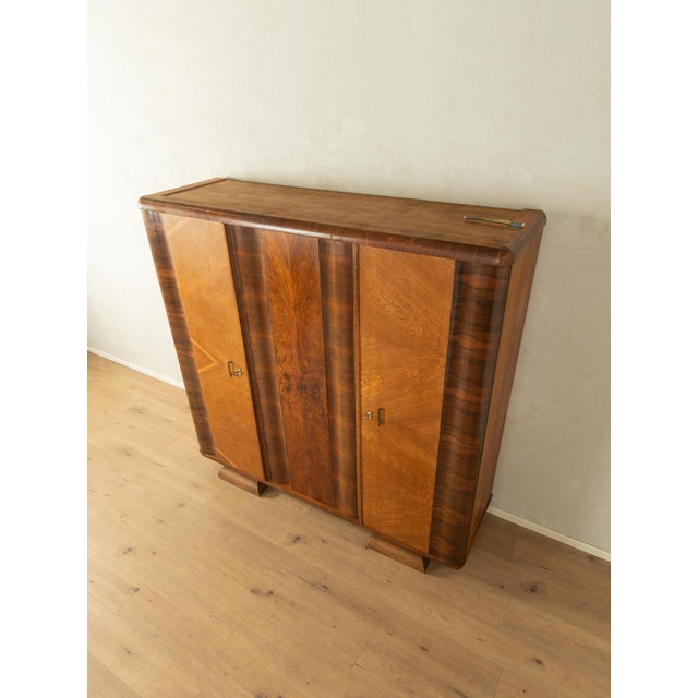 A wonderful Art Deco wardrobe from the 1920s. High-quality walnut veneer frame with three doors, five shelves, two clothes...