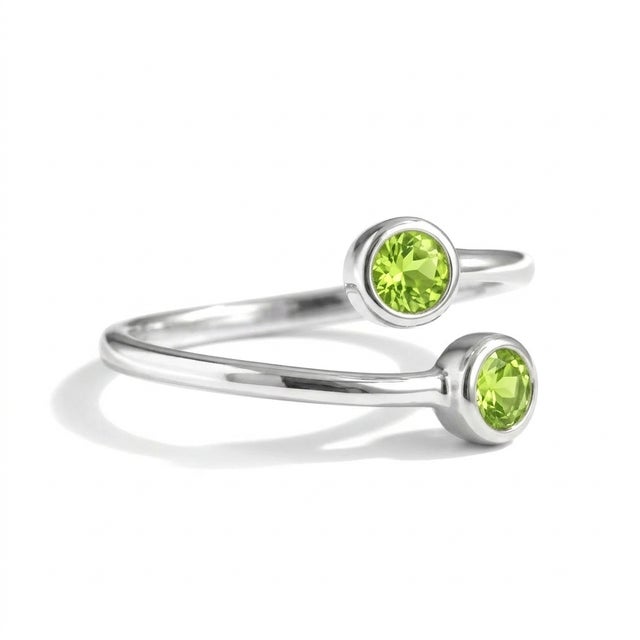 This modern and elegant open ring features vibrant Peridot gemstones, celebrated for their fresh green brilliance and...