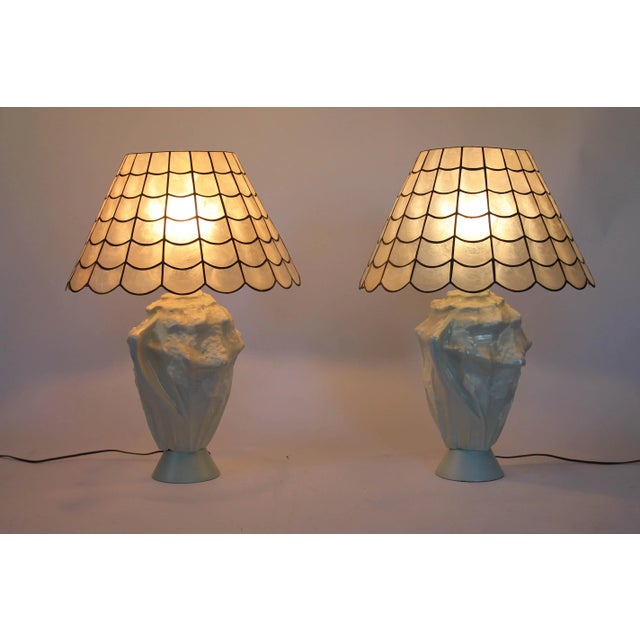 Pair of ceramic iridescent light blue faux conch shell table lamps with capiz sea shell shades. Wired and in working...