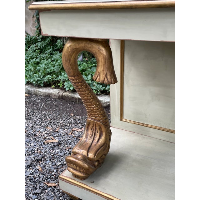 This is a lovely Venetian style painted side table with carved giltwood dolphin supports and gilt trim. The table has an...