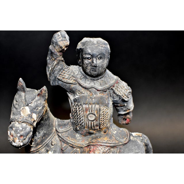 An all original, 18th century, hand carved, solid wood statue of a young Ming dynasty warrior on horse. Warrior wears a...