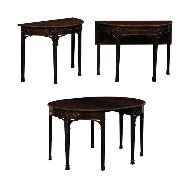 An English pair of Regency period, ornately carved demi lune style tables, or single oval table when joined, from the...