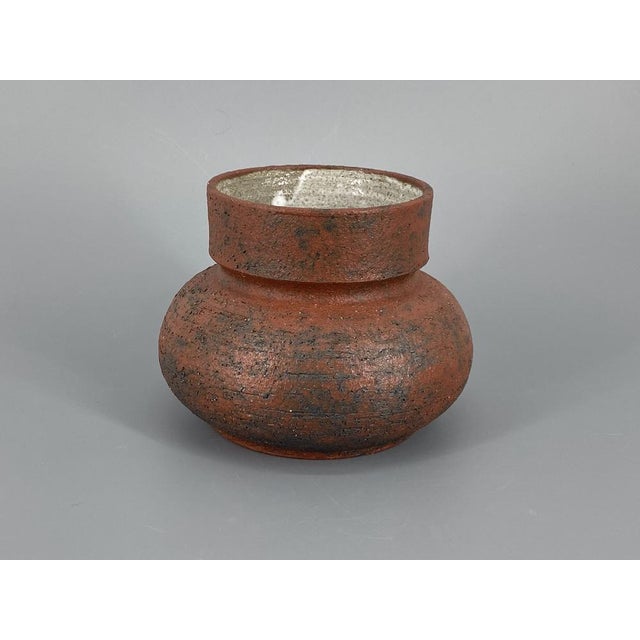 A vase * Made of reddish-brown stoneware with an additive * Interesting, coarse surface texture * White glazed interior *...