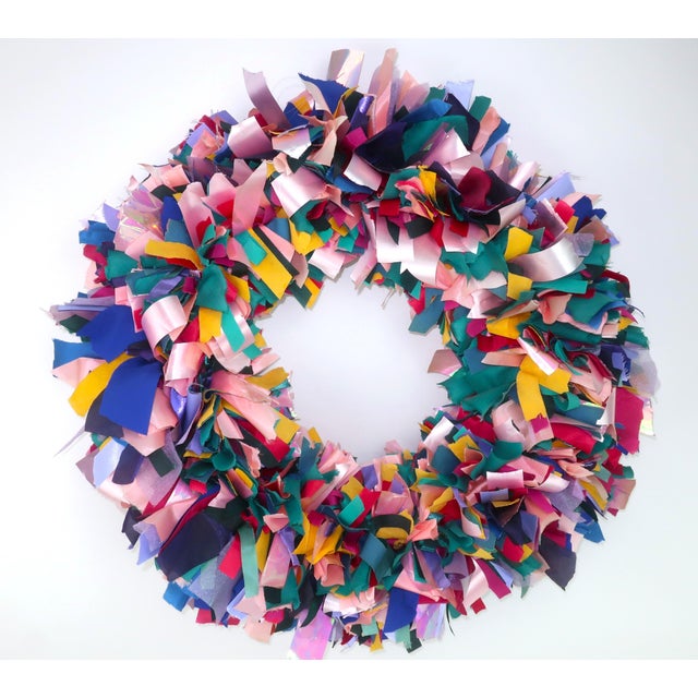 1980's confetti style holiday wreath created with a colorful abundance of ribbon in shades of pink, green, blue, purple,...