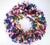 1980's confetti style holiday wreath created with a colorful abundance of ribbon in shades of pink, green, blue, purple,...