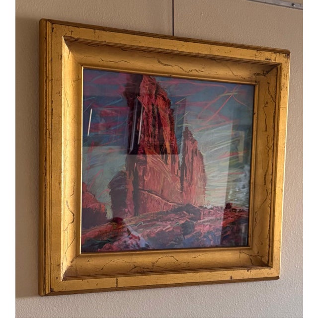 This artwork depicts a dramatic landscape featuring towering rock formations bathed in vibrant hues of orange and red,...