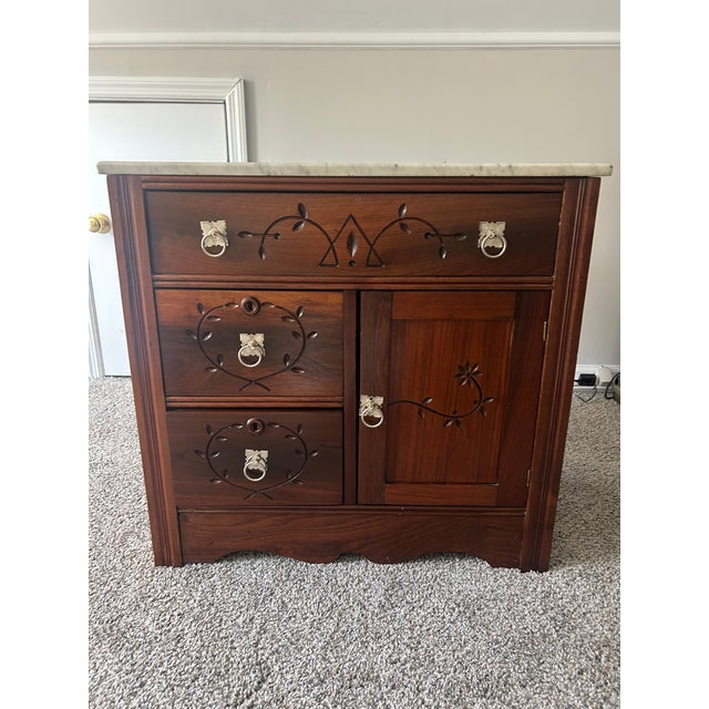 A beautifully detailed Late Victorian washstand in walnut, circa 1880s, featuring an intact original marble top and...