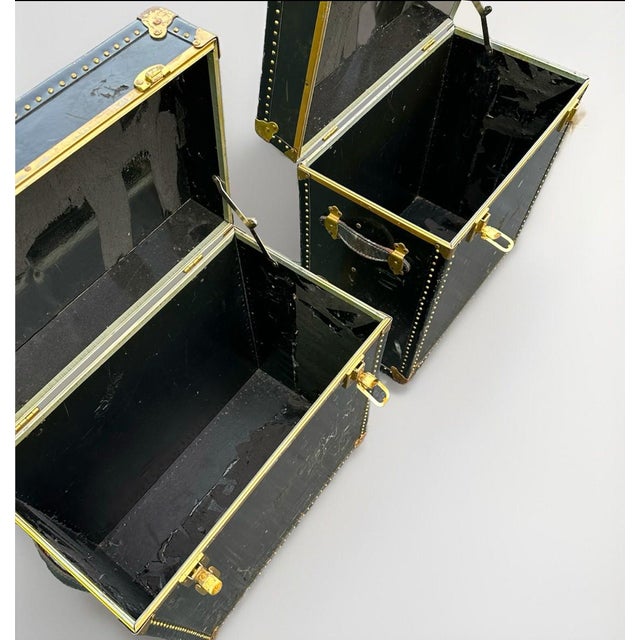 Pair of vintage Meek's leather campaign luggage trunks. These storage tables are black in color, standing at a height of...