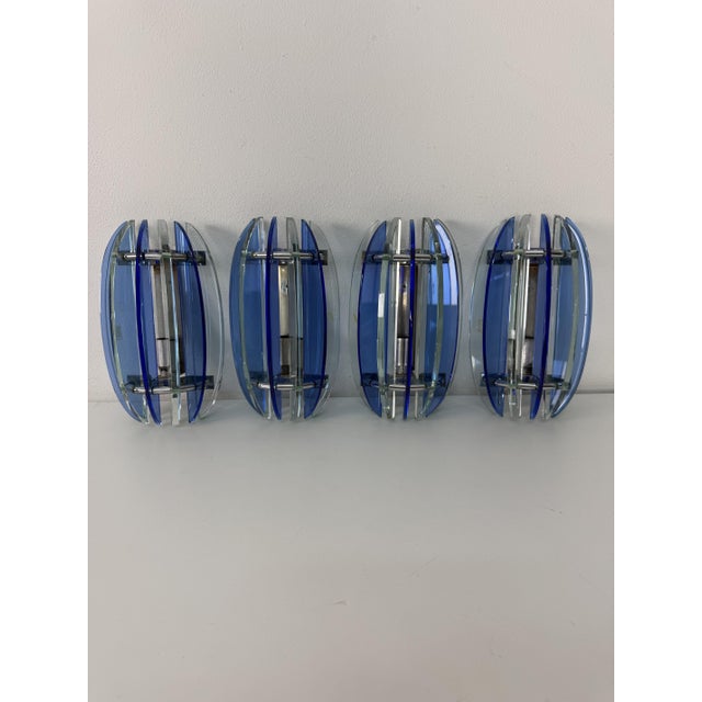 Set of 4 "VECA" wall lamps, Made in Italy, 1970 They feature an elliptical structure composed of thick glass slats in blue...