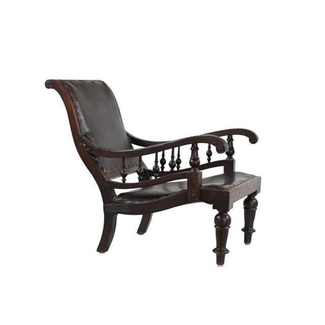 This Antique Antique Anglo-Indian Teakwood Library/Lounge Chair is handcrafted from solid teakwood, featuring gracefully...