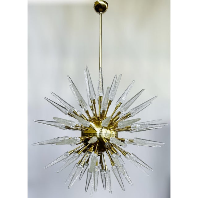 Italian modern Sputnik chandelier with clear Murano glass shards spikes, mounted on unlacquered natural brass finish frame...