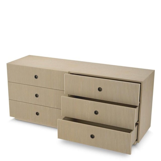 Dresser in washed oak veneer and bronze finish. Its front features ribbed wooden panels that create a regular relief and a...