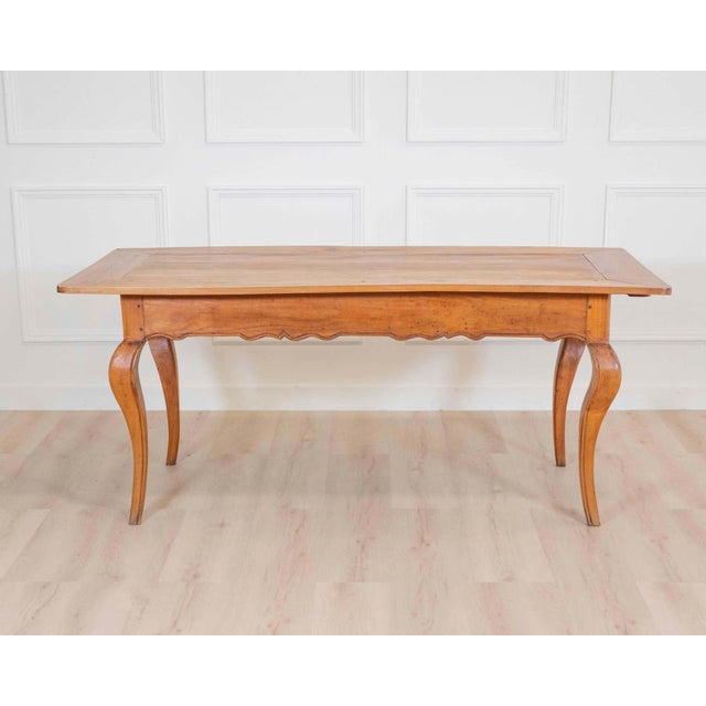A beautifully proportioned French 19th century provincial farm table, handcrafted in warm walnut with a wonderfully time-...