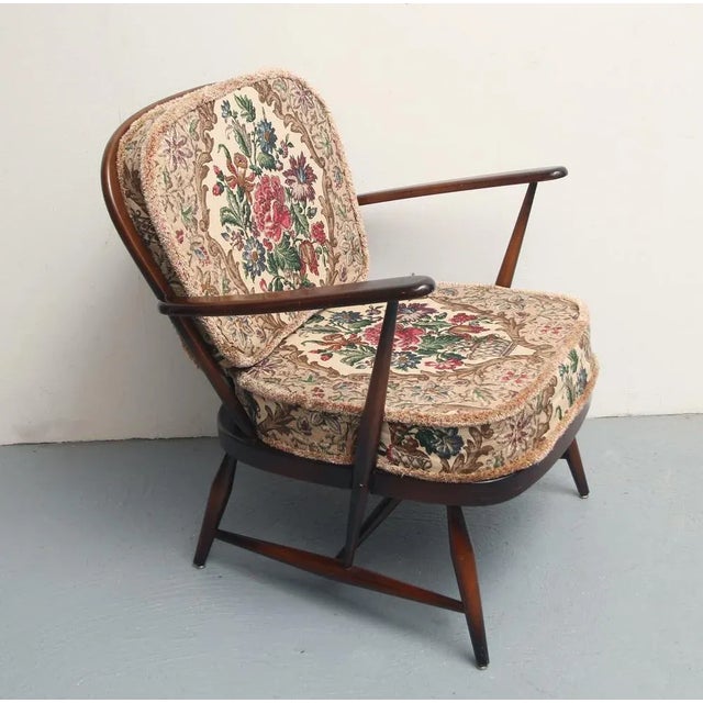 50s Armchair by Ercol/UK. Design Lucian Ercolani. Dark solid wood. With removable cushion in original cover, floral...