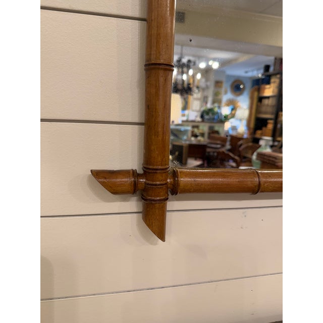 This is a French antique faux-bamboo wall mirror with a hand-carved wood frame. The frame is wood that has been shaped and...