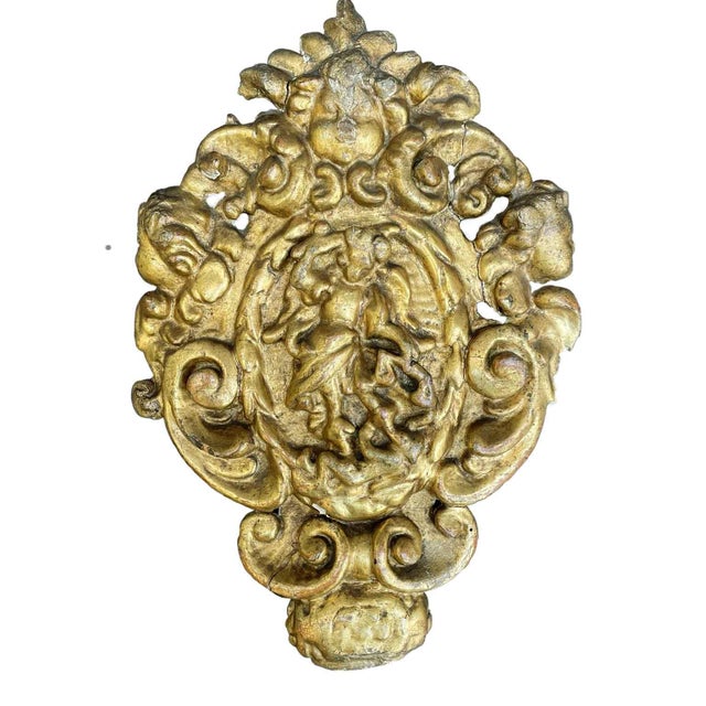 Pair of richly carved gilded friezes in lime wood with a central oval panel depicting Saint Michael brandishing a sword in...