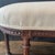 Elegant 19th century French Louis XVI walnut bench or ottoman featuring a long oval upholstered seat above a carved apron...