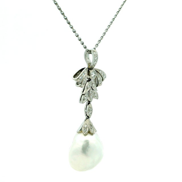 The platinum design is beautifully detailed with graceful ribbon and foliate motifs, set throughout with approximately...