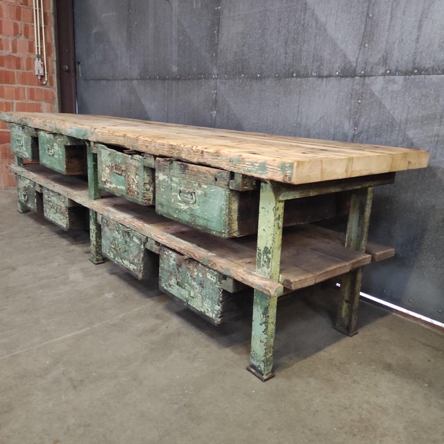 This large industrial workbench (330x88x86 cm) is a striking piece with a metal frame, rich green patina and a solid,...