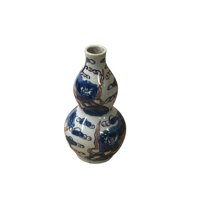 This charming double gourd porcelain vase features a vibrant, hand-painted scene of Buddhist Lions (Foo Dogs) amidst...