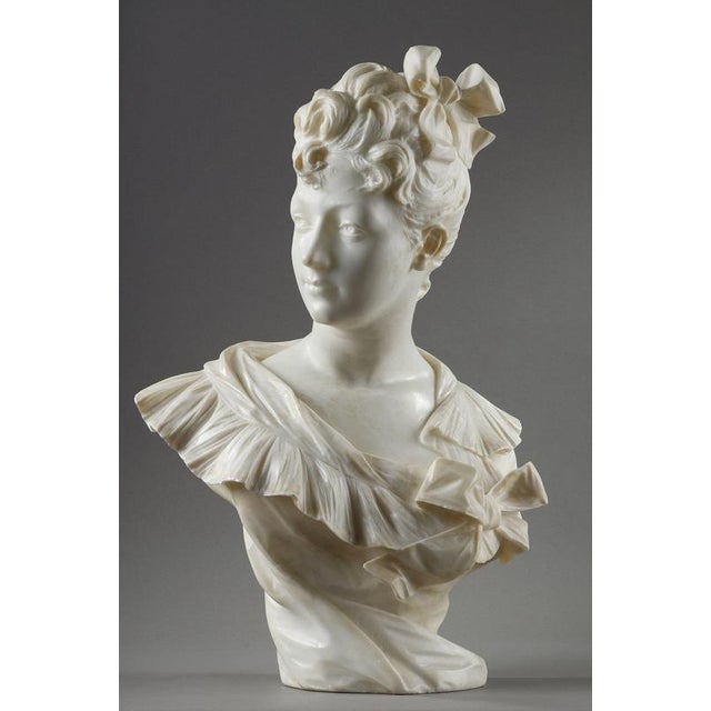Bust of a beautiful woman in a corset held in place by a bow, with her face turned to the side exposing her profile. This...