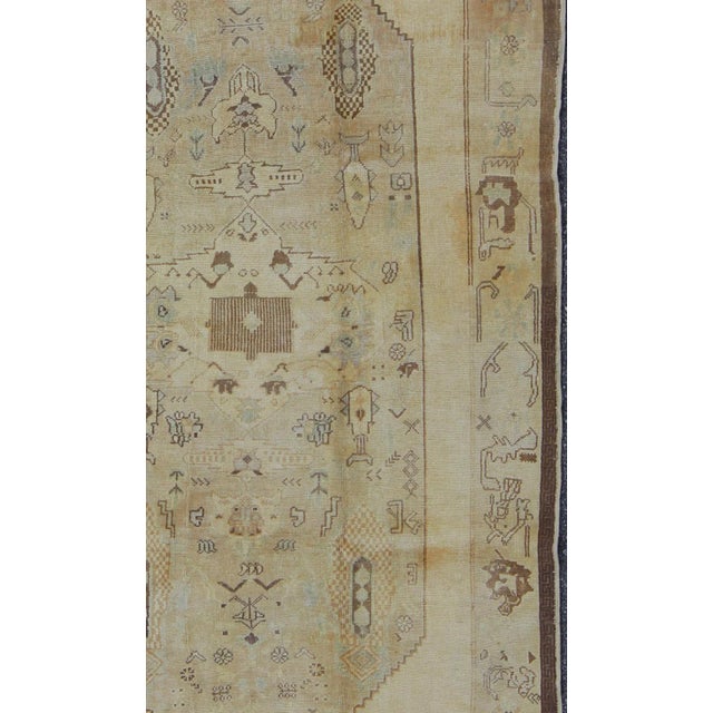 Measures: 5'6 x 9'5. Vintage Turkish Oushak Rug Featuring Faded Camel, Ivory, and Pale Blue Accents. Keivan Woven Arts /...