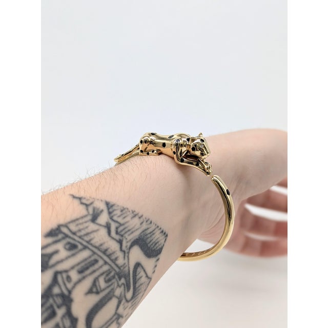 Rawr! This chunky solid 14k yellow gold leopard bangle with black enamel spots and glittering earth-mined diamond eyes is...