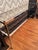 Elegant vintage chrome and glass console table featuring a sleek architectural frame with decorative brass-tone finials....