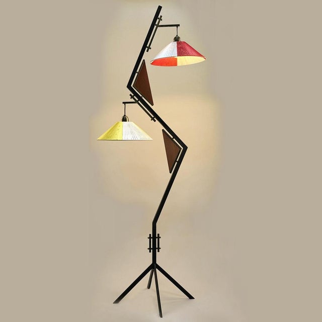 Elegant Italian floor lamp dating from the 1950s, featuring a sculptural black-painted angular metal frame accented with...