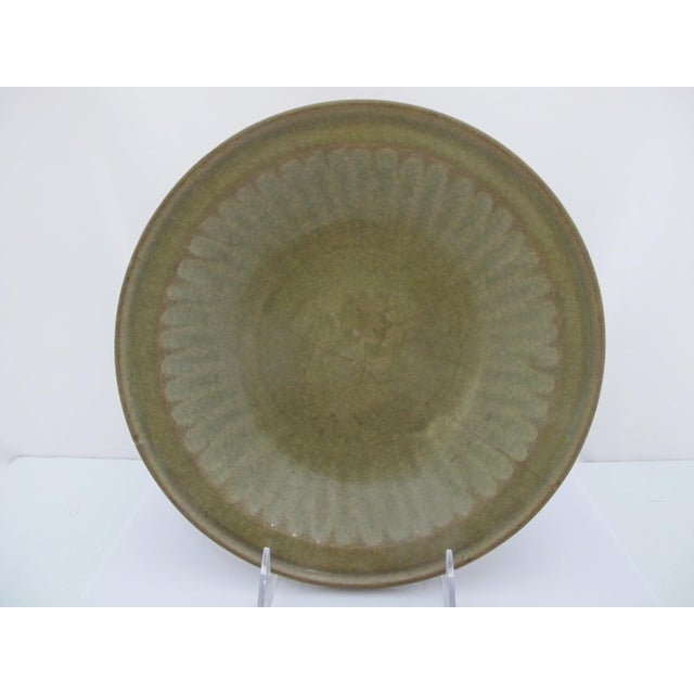 Chinese Longquan Ming style Celadon glazed pottery dish or shallow bowl. Olive green Celadon glazed pottery with carved...