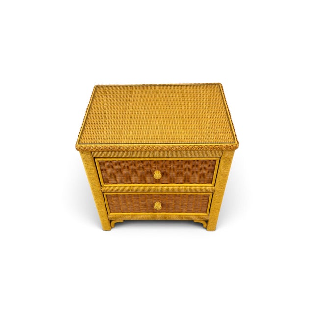 A charming vintage Henry Link two-drawer wicker nightstand dating to the 1980s, featuring the relaxed coastal style for...