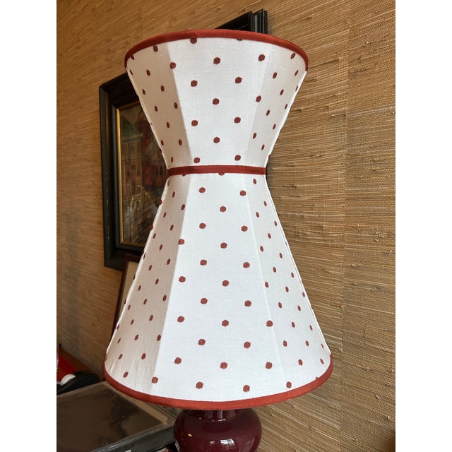 An hourglass lampshade made of white linen with embroidered chestnut polka dots and chestnut trim. Top: 10.25" across...
