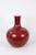 This vase is glazed in a red that allows subtle relief detail to be seen. Has some damage, big crack .