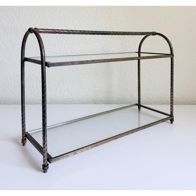 A vintage circa 1960s-1970s two-tier tabletop display shelf or etagere with an aged brass metal frame and inset glass...