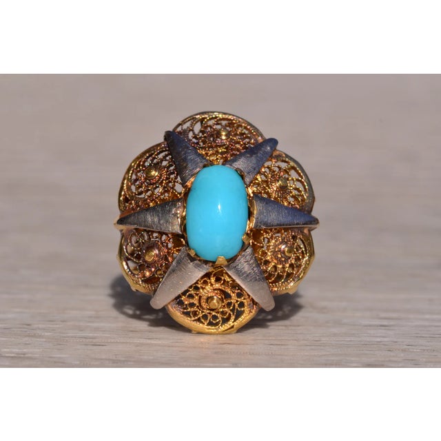 The Corrigin: Antique Filigree Persian Turquoise Ring. The ring features a central elongated oval natural turquoise...