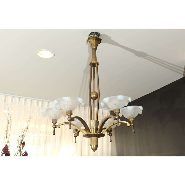 This French Art Deco chandelier by Petitot features six original waterfall opaline glass shades on antique brass. The...