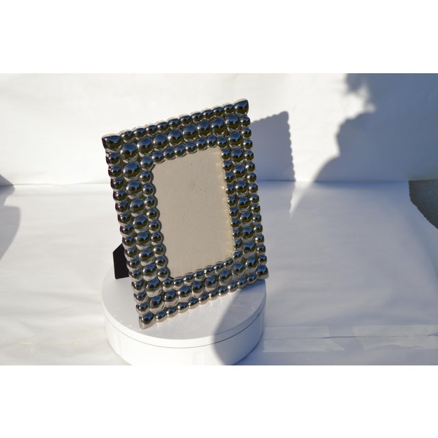 Holds a picture the size of 3.75x 5.75 inches. Mirrored bubbled frame and glass are both in good condition. Minimal wear...