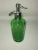 A green glass Spitzer and Company seltzer bottle displaying the American flag. Established 1838, 26 ounces.