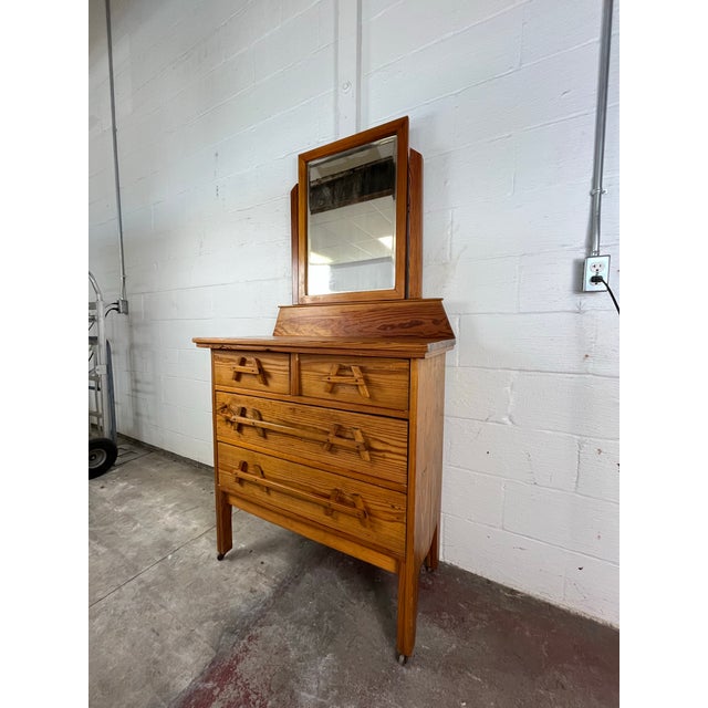 This mid-century pine dresser showcases clean lines, natural grain movement, and sculptural wooden unique A-frame latch-...