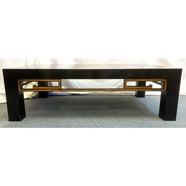 Timeless vintage Chinoiserie style coffee table from the mid 20th century. It is made of wood in a black lacquer finish...
