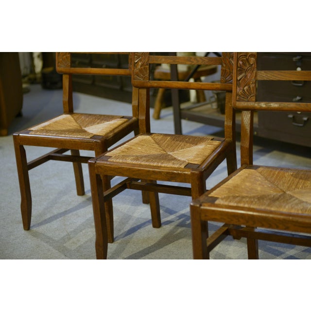 An elegant set of six oak chairs, French craftsmanship in the Art Deco style, circa 1930. The straight backs are adorned...