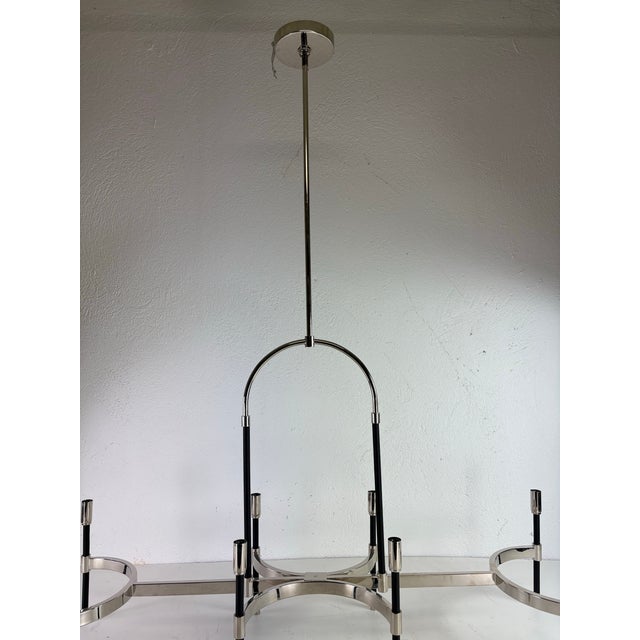 This is a late 20th century Ralph Lauren nickel and leather chandelier. This elongated chandelier is nickel plated with...