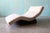 A mid century modern wave style chaise lounge. Sits on a trapezoidal upholstered plinth base. Similar stylings to Adrian...