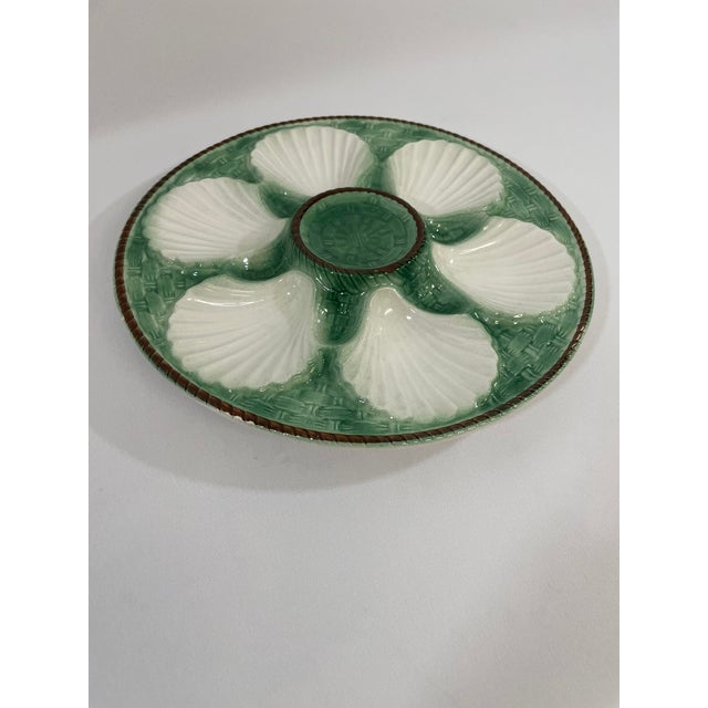 A striking antique French Faience Longchamp glazed majolica oyster plate with a vibrant green basket weave background and...