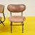 This set of chairs, an icon of vintage design, features a lightweight metal frame and comfortable brown faux leather...