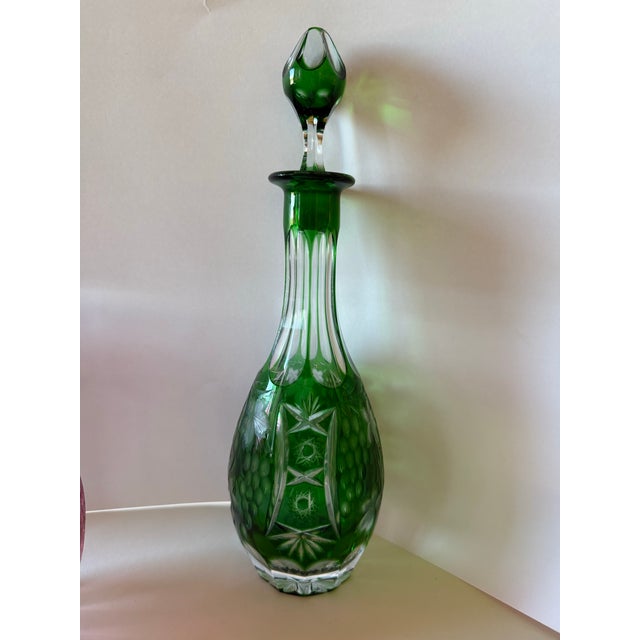 A tall, elegant wine decanter in deep emerald green cased over clear crystal, hand-cut in the classic Bohemian/Bavarian...