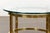 An Italian Midcentury brass side table from circa 1950 with circular glass top. Indulge in the elegance of the 1950s with...