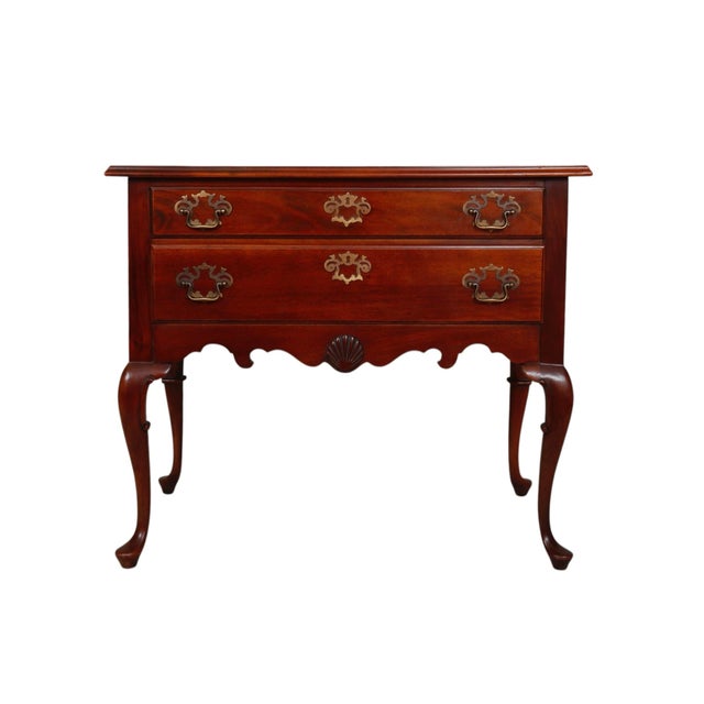 A Queen Anne style lowboy in mahogany, made by Hickory Chair Company. Two dovetailed drawers open with bail handles on...