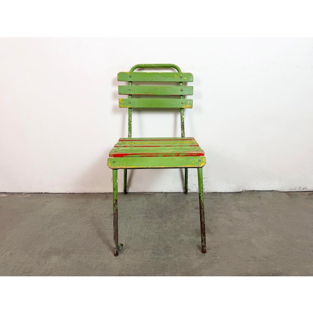 This green chair was made in former Czechoslovakia during the 1960. It features an iron construction and a wooden seat and...